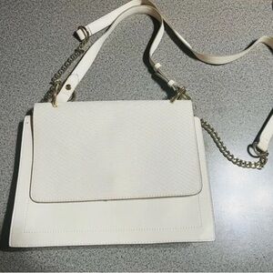 Express crossbody strap with chain hardware and a hand handle.